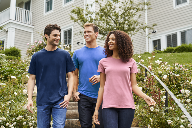 A group of friends wearing cotton and polyester blank apparel walking outside.